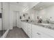 Bright bathroom featuring a double vanity with granite counters, white cabinets, and a tiled walk-in shower at 399 N 157Th Ln, Goodyear, AZ 85338