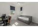 Bedroom with gray walls featuring a bed with drawer storage, desk, and sunny windows at 399 N 157Th Ln, Goodyear, AZ 85338
