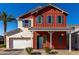 Charming two-story home features a red exterior with blue shutters and a well-manicured front yard at 399 N 157Th Ln, Goodyear, AZ 85338