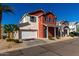 Charming two-story home features a red exterior with blue shutters and a well-manicured front yard at 399 N 157Th Ln, Goodyear, AZ 85338