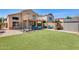 Large backyard featuring manicured artificial turf, covered patio, sitting area, and a storage shed at 4050 W Camino Del Rio --, Glendale, AZ 85310
