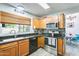 Efficient kitchen featuring wood cabinetry, stainless steel appliances, black granite countertops, and a modern backsplash at 4050 W Camino Del Rio --, Glendale, AZ 85310