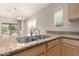 Close up of kitchen featuring granite counters, stainless steel sink and faucet, and large windows at 4176 E Bonanza Rd, Gilbert, AZ 85297