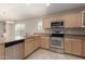 Well-lit kitchen featuring stainless steel appliances, light wood cabinetry, and granite countertops at 4176 E Bonanza Rd, Gilbert, AZ 85297