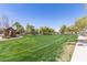 Community park with large grassy area, mature trees, walking path, and shaded pavilion at 4176 E Bonanza Rd, Gilbert, AZ 85297