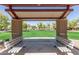 Shaded park pavilion view overlooking green grass and mature trees, including two benches at 4176 E Bonanza Rd, Gilbert, AZ 85297