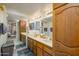 Well-lit bathroom with double sinks, wood cabinets, large mirrors, and tile flooring at 4303 E Cactus S Rd # 329, Phoenix, AZ 85032