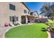 Backyard featuring a covered patio, green artificial turf, and lounge chairs at 44235 W Mcclelland Dr, Maricopa, AZ 85138