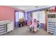 A pink and purple bedroom with many toys and a window view at 44235 W Mcclelland Dr, Maricopa, AZ 85138