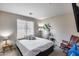 Cozy bedroom with neutral walls and carpet, features a queen bed and rocking chair at 44235 W Mcclelland Dr, Maricopa, AZ 85138