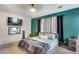 The bedroom features a queen-sized bed, side tables, and a wall mounted TV at 44235 W Mcclelland Dr, Maricopa, AZ 85138