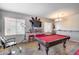 Spacious game room features a pool table with red felt, modern lighting, and a stylish salon chair at 44235 W Mcclelland Dr, Maricopa, AZ 85138