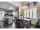 Modern kitchen with gray cabinets, granite countertops, and a breakfast bar overlooking the dining area, ideal for gatherings at 44235 W Mcclelland Dr, Maricopa, AZ 85138