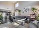 Cozy living room showcases a sectional sofa, high ceilings, and large monochromatic art prints accenting the tall walls at 44235 W Mcclelland Dr, Maricopa, AZ 85138