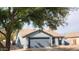 Charming single-story home with a two-car garage and mature landscaping, shaded by a large tree at 444 W Fabens Ln, Gilbert, AZ 85233