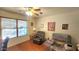 Cozy living room offers hardwood floors, a ceiling fan, and plush seating with ample natural light from the window at 444 W Fabens Ln, Gilbert, AZ 85233
