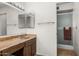 Functional bathroom with a sink vanity, ample lighting, and a glass door shower at 5741 W Purdue Cir, Glendale, AZ 85302