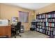 Functional bedroom providing a dedicated study space with a bookcase and natural light from the window at 5741 W Purdue Cir, Glendale, AZ 85302