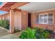 Inviting brick entryway with a security camera, manicured landscaping, and shuttered window at 5741 W Purdue Cir, Glendale, AZ 85302