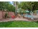 Charming backyard area with a brick patio, seating, mature trees, and pool views at 601 E Winter Dr, Phoenix, AZ 85020