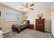Comfortable bedroom featuring plantation shutters, ceiling fan, dresser, and nightstand at 601 E Winter Dr, Phoenix, AZ 85020