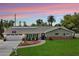 Charming single-story home with a well-manicured lawn, solar panels, and inviting front porch seating area at 601 E Winter Dr, Phoenix, AZ 85020