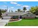 Charming single-story home with a well-manicured lawn, solar panels, and inviting front porch seating area at 601 E Winter Dr, Phoenix, AZ 85020