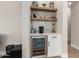 Chic bar area with open shelving, mosaic tile backsplash, and beverage refrigerator at 6209 E Bramble Berry Ln, Cave Creek, AZ 85331