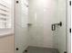 Modern bathroom shower with sleek glass enclosure, white marble tile and stylish black fixtures at 6209 E Bramble Berry Ln, Cave Creek, AZ 85331