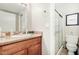 Bathroom featuring a single sink with granite countertop, framed mirror, toilet, and a glass-enclosed shower at 623 W Guadalupe Rd # 214, Mesa, AZ 85210