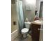 Bathroom features a shower/tub combo with light blue curtain, single sink vanity, toilet and neutral paint at 623 W Guadalupe Rd # 214, Mesa, AZ 85210