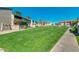 Lush community grounds with manicured lawns, flowering shrubs, and paved walkways, enhancing curb appeal at 623 W Guadalupe Rd # 214, Mesa, AZ 85210
