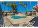 Community pool and lounge area surrounded by palm trees and community buildings for residents to enjoy at 623 W Guadalupe Rd # 214, Mesa, AZ 85210