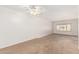 Large bedroom with neutral carpet, ceiling fan and view of exterior at 6608 S Willow Dr, Tempe, AZ 85283