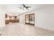 Bright living room featuring tile flooring, a ceiling fan, and a view of the kitchen and backyard pool at 6608 S Willow Dr, Tempe, AZ 85283