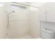 All-white tiled shower with adjustable shower head and built in shelving niche at 6608 S Willow Dr, Tempe, AZ 85283
