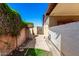 Narrow side yard access gate from the front yard with block fencing and a desert landscape at 6608 S Willow Dr, Tempe, AZ 85283
