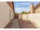 View of the home's side yard with a pathway and privacy wall under a blue sky at 6608 S Willow Dr, Tempe, AZ 85283