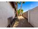 Narrow side yard between white block fence and house with desert landscaping with two palm trees at 6608 S Willow Dr, Tempe, AZ 85283