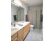 Bright bathroom featuring a double sink vanity with wood cabinets and a shower-tub combination with a neutral shower curtain at 8755 E Gary Rd, Scottsdale, AZ 85260