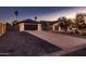 Home featuring a gated entrance and three-car garage, along with mature landscaping at 8755 E Gary Rd, Scottsdale, AZ 85260