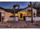 Inviting front entrance with a black front door, lush flowers, and rock landscaping at 8755 E Gary Rd, Scottsdale, AZ 85260