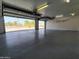 Bright garage with epoxy floor, shelving, and view to outside at 8755 E Gary Rd, Scottsdale, AZ 85260