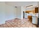 Cozy kitchen with wooden cabinets, white appliances, and a view of the living space with tiled floors at 8755 E Gary Rd, Scottsdale, AZ 85260