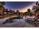 Stunning backyard oasis with a freeform pool, sun loungers, shaded cabana, and lush landscaping at 8755 E Gary Rd, Scottsdale, AZ 85260