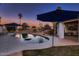 Inviting backyard pool with lounge chairs, patio, and manicured landscaping under a colorful sunset sky at 8755 E Gary Rd, Scottsdale, AZ 85260
