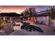 Captivating pool area with solar panels, lounge chairs, and patio under a mesmerizing sunset backdrop at 8755 E Gary Rd, Scottsdale, AZ 85260