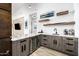 Modern bar area features custom cabinets, floating shelves, stainless steel refrigerator, and granite countertops at 9127 N Fireridge Trl, Fountain Hills, AZ 85268