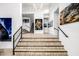 Bright foyer with hardwood flooring, modern art, and a split staircase at 9127 N Fireridge Trl, Fountain Hills, AZ 85268