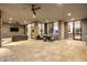 Expansive patio with stone flooring, ample seating, and seamless transition to interior spaces through large glass doors at 9127 N Fireridge Trl, Fountain Hills, AZ 85268